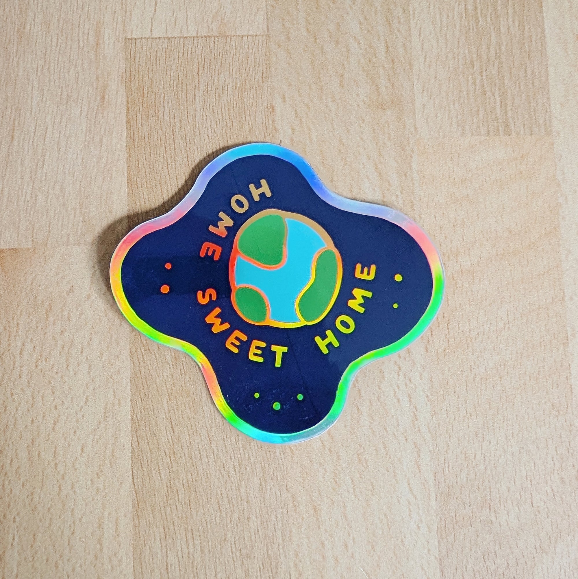 Holographic vinyl sticker featuring planet earth floating in space with the words Home Sweet Home