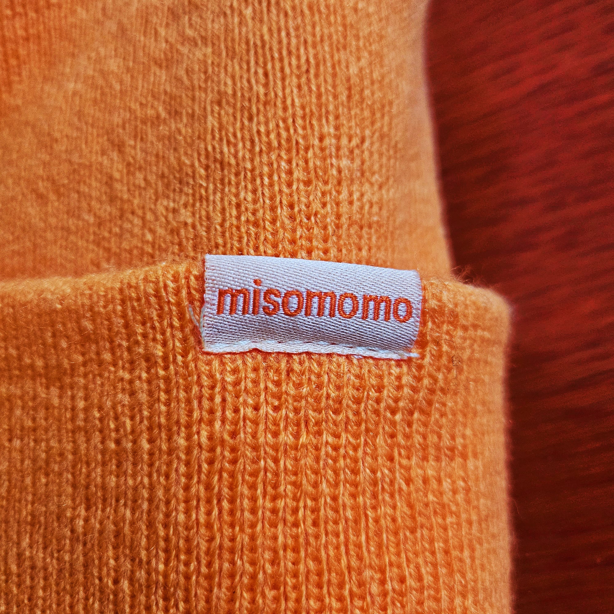 close up image of the brand logo tag on the edge of the misomomo sprout leaf beanie