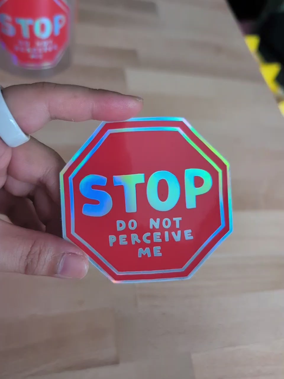 video of a vinyl sticker in the shape of a stop sign that reads "STOP do not perceive me"