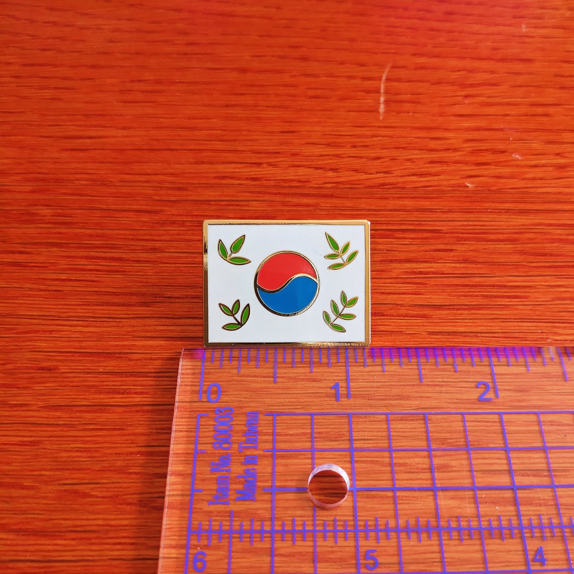 misomomo leafy Korean flag enamel pin pictured with a ruler to show that pin is just over one inch in width