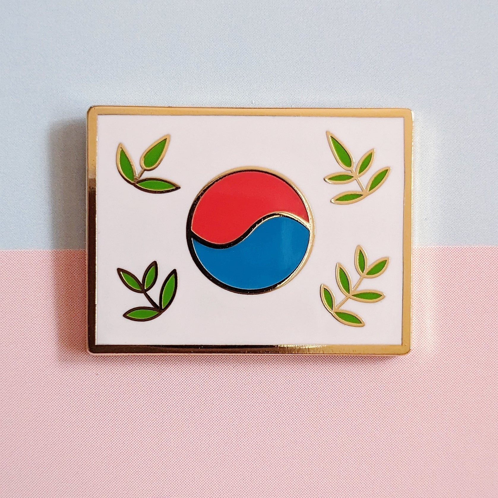 closeup of a misomomo stylized leafy Korean flag (taegukgi) enamel pin